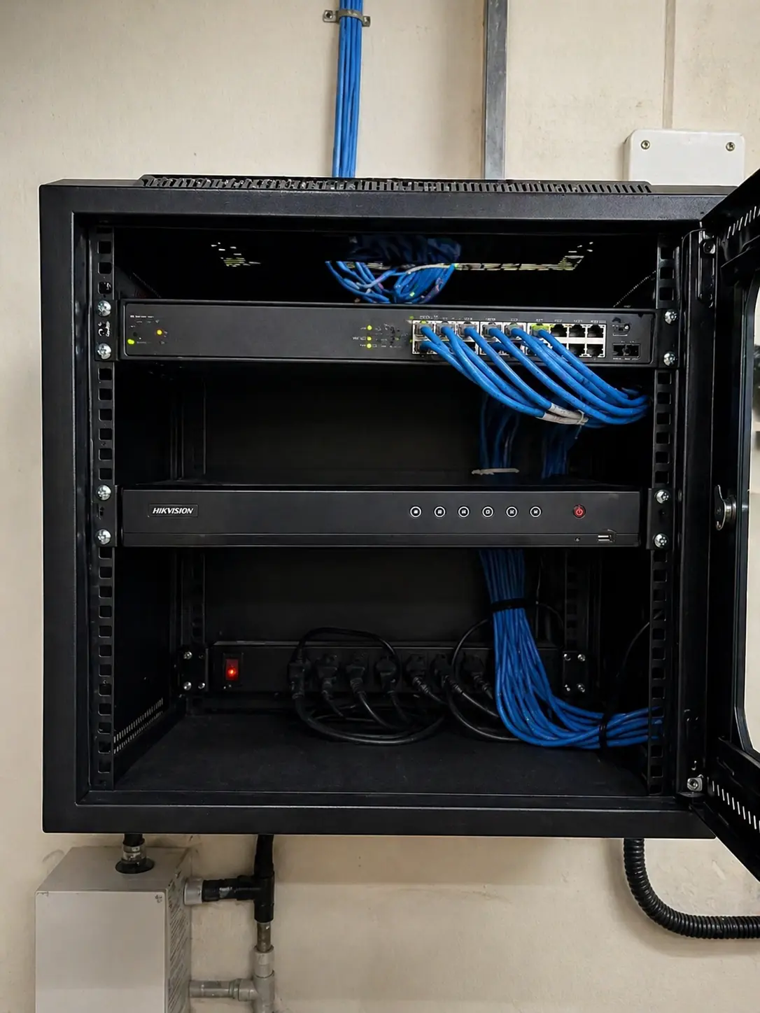 Rack de rede com switch PoE Hikvision e DVR instalado pela LASE TECH